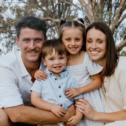 Photo of a family of four, posing to camera.