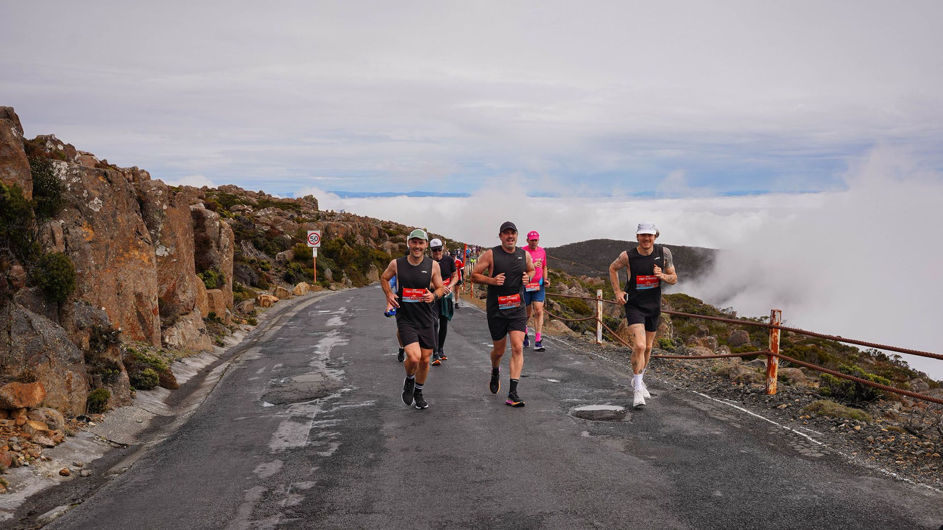 Photo of athletic runners ascending a mountainous road as part of the Peak to Pinnacle half-marathon in Hobart.