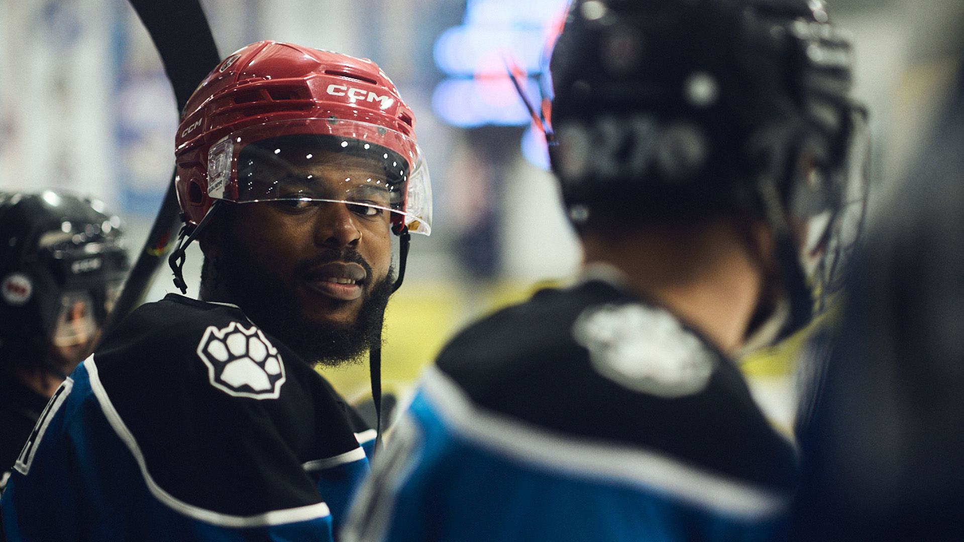 Photo of two young men in hockey gear, about to play a game.